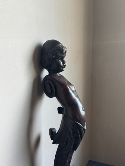 A carved cherubic term